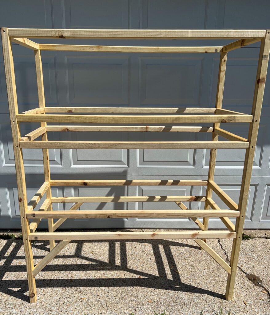 Quail hutch made out of furring strips in front of garage door
